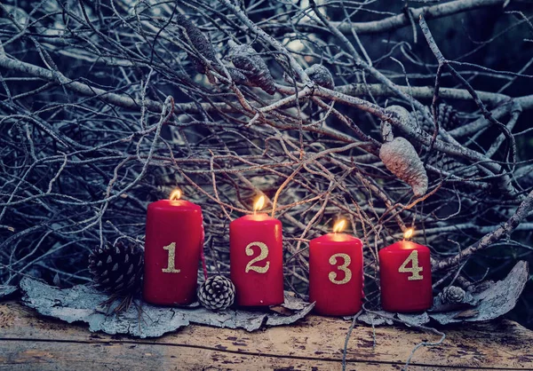 Four red advent candles with numbers