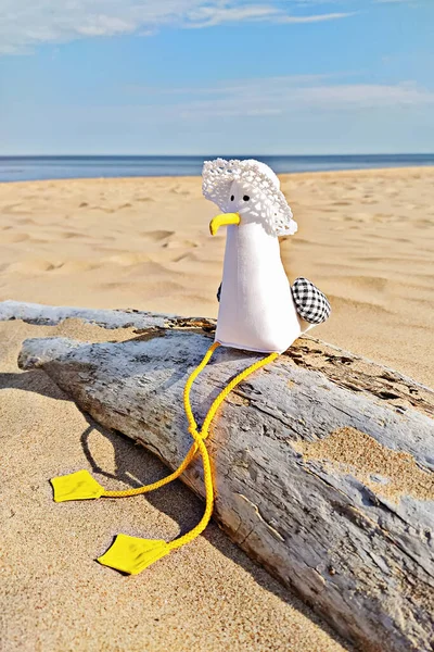 Toy seagull with hat sits on log, summer vacation concept — Stock Photo, Image