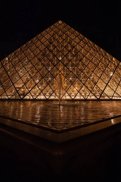 PARIS, FRANÇA: Vista do famoso Museu do Louvre com Pirâmide do Louvre à noite . — Fotografia de Stock