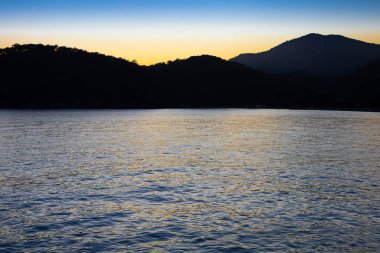 Deniz ve dağların üzerinde gün batımı