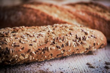 Kırsal ahşap masanın üzerinde farklı tohumlarla taze ekmeklerin Macro manzarası..