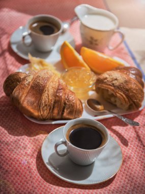 Lezzetli kıta kahvaltısı taze kruvasan, çeşitli reçeller, portakal suyu, mısır gevreği ve kahve, kruvasanlara yakın.
