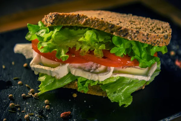 Peynirli ızgara çavdar sandviçi, ıspanak, pesto, avokado ve keçi peyniri. Tonlama. seçici odak