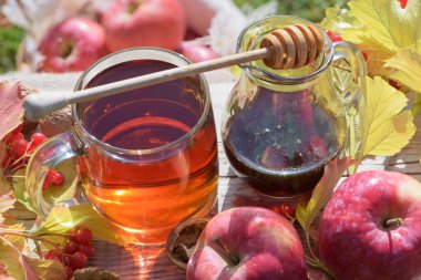 Üst taraf sıcak bitkisel çay ve karabuğday balı ve cevizli taze elmalar ve kırsal güvertede viburnum üzümü. Sonbahar durgun hayat 4.