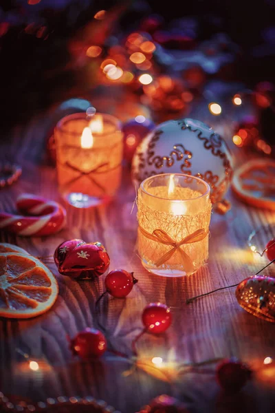 Bir çift sihirli Noel süslenmiş, ahşap arka planda yanan mumlar..