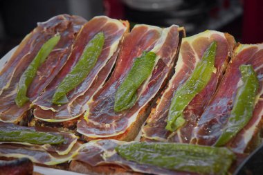 Jamon iberico ile ızgara ekmek ve fırında yeşil biber. Seçici odak.