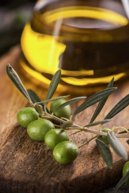 Kırsal arka planda zeytin dalıyla cam şişede ekstra saf zeytin yağı. makro görünüm