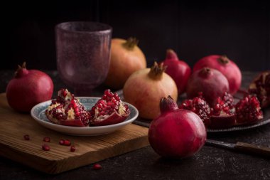 Nar, taze nar meyveleri ve kırsal arka planda çekirdekleri olan durgun bir hayat. alçak tuş