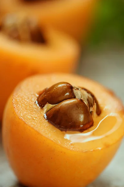 Taze taze Loquat Nispero gri arka planda naneli yapraklarla tatlandırılmış. Seçici odaklanma. Makro görünüm.