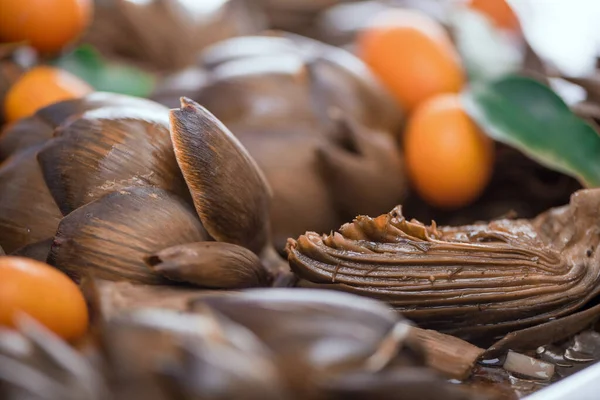 Tahta arka planda Kumquat olan lezzetli Roma tarzı enginarlar, makro. Yumuşak odak