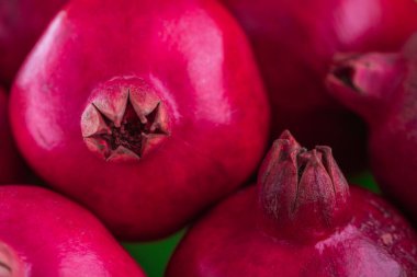 Taze olgun kırmızı narlar yeşil arka planda yakın temasta. 3