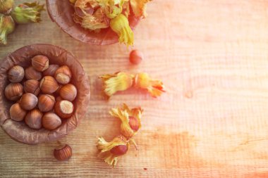 Köy tahtasında kurumuş yapraklarla dolu bir tabakta toplanmış fındık kabuklarından oluşan düz bir fotoğraf kompozisyonu vardı. Seçici odaklanma. Ton halinde. Boşluğu kopyala.