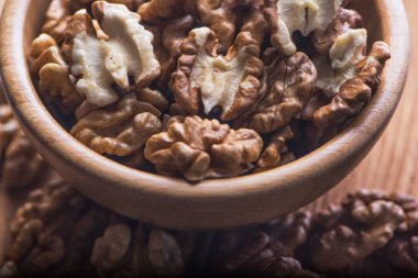 Ukrayna 'ya ait geniş, kurumuş, ahşap bir kasede kabuğu soyulmuş Walnut çekirdekleri grubunun yakın görüntüsü. Seçici odaklanma. Alçak tuş