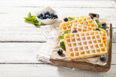 Lezzetli geleneksel Belçika waffle tabağı ve taze yaban mersini.