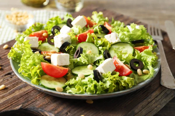 Tallrik Med Välsmakande Grekisk Sallad Färska Grönsaker Trä Bakgrund — Stockfoto