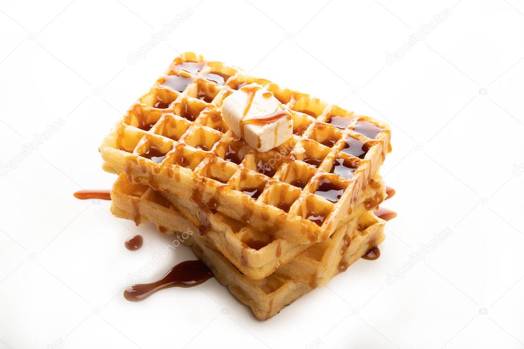 Delicious Belgian waffles with caramel topping isolated on a white background