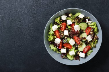 Siyah arka planda taze sebze salatası tabağı. Metin için yer