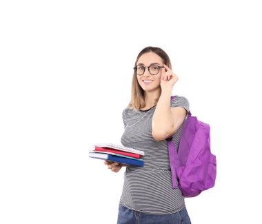 Sırt çantalı güzel bir kız öğrenci beyaz bir arka planda izole edilmiş defterleri elinde tutuyor.