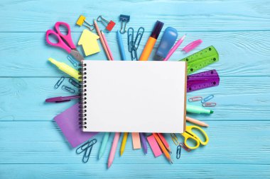 Mavi arka planda okul defteri ve kırtasiye malzemesi. Yukarıdan görüntüle