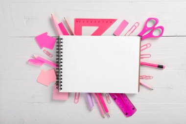 Okul defteri ve beyaz arka planda çeşitli kırtasiye malzemeleri. Eğitim kavramı