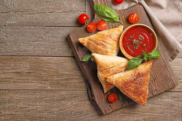 Masada lezzetli etli samosa 'lı ahşap tahta tahta.