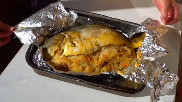 Female hands unfolding of baked fish in foil — Stock Video