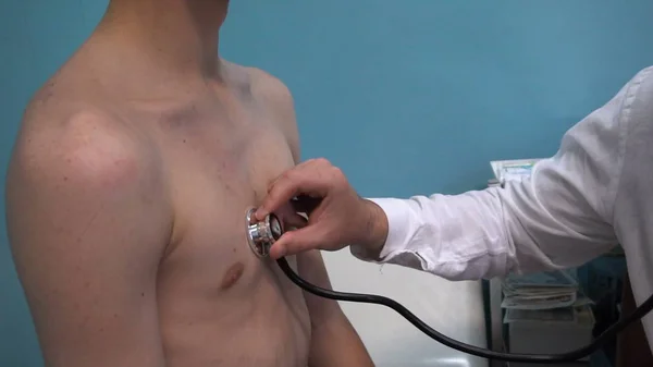 Doktor steteskopla hastanın ciğerlerini dinliyor.
