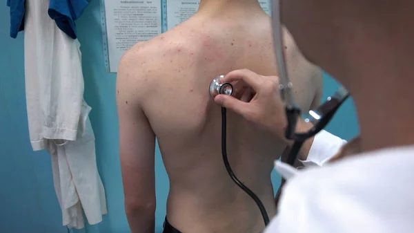 Doktor steteskopla hastanın ciğerlerini dinliyor.