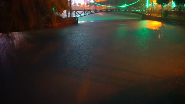 Regen op een rivier tegen een kleurrijke brug — Stockvideo