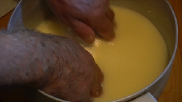 Hand in heiß fermentierte Schafsmilch sammelt große Klumpen Käse in einem hölzernen Bucketmaking Käse von Schafsmilch manuell alten Traditionen Berge — Stockvideo