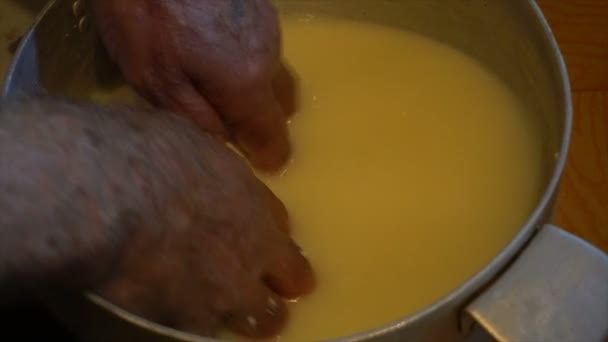 Hand in heiß fermentierte Schafsmilch sammelt große Klumpen Käse in einem hölzernen Bucketmaking Käse von Schafsmilch manuell alten Traditionen Berge — Stockvideo