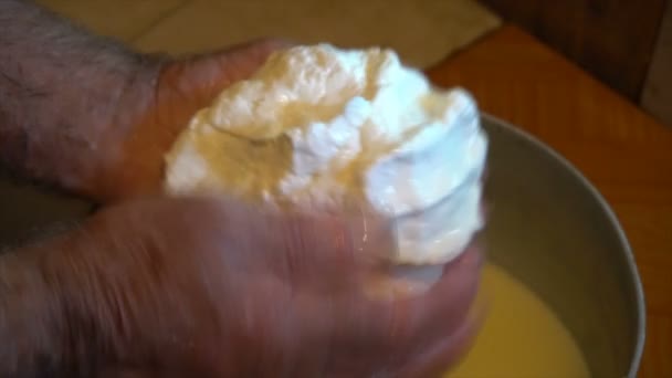 Hand i heta jästa sheeps mjölk samlar stor klump ost i en trä bucketmaking ost från fåren mjölk manuellt gamla traditioner berg — Stockvideo