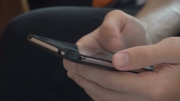 Händer thumbing genom en smartphone närbild. — Stockvideo