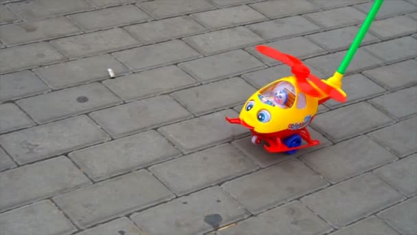 Child rolls a toy helicopter in the park — Stock Video