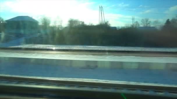 4K Ponto de vista da janela de um comboio de passageiros. A floresta deserta de inverno se move fora da janela — Vídeo de Stock