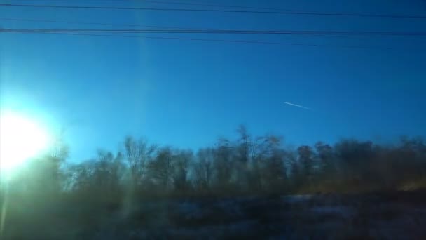 Samolot na niebie na tle jasne zimowe słońce, widok z pociągu — Wideo stockowe