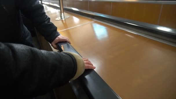 Les gens se déplacent sur un escalator, la main humaine sur la rampe — Video