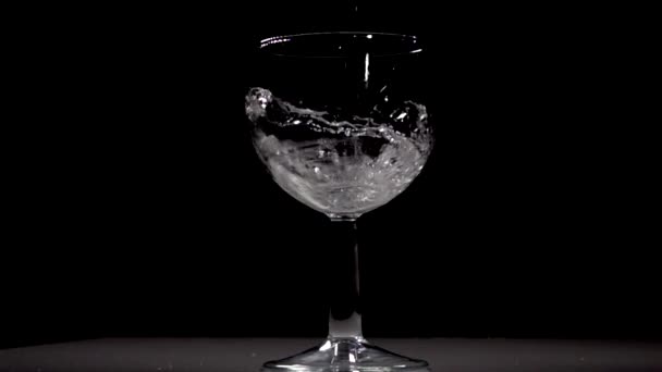 Zeitlupe Gießt Wasser Weinglas Vor Schwarzem Hintergrund — Stockvideo