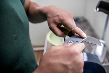 bir adam bunu keskin bir bıçak keskinleştirir