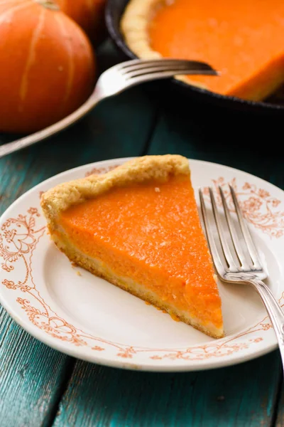 Piece of traditional homemade pumpkin pie on white plate vertical