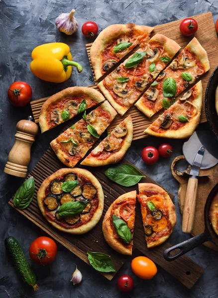 Flatlay of vegetarian pizza party. Homemade rustic pizzas with t