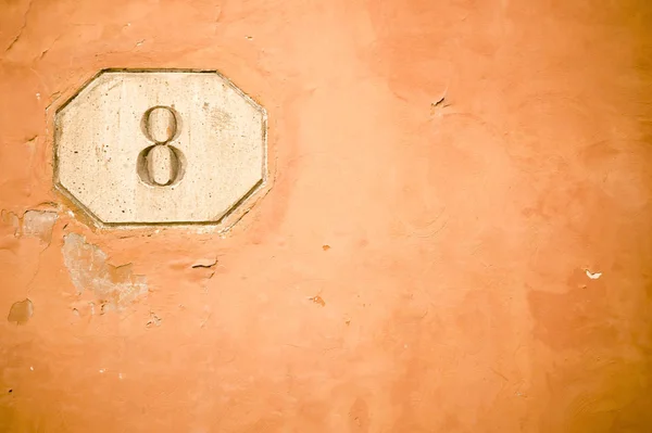 Numer osiem w starej ścianie — Zdjęcie stockowe