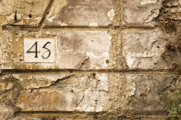 Número quarenta e cinco na parede velha — Fotografia de Stock