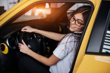 Arabanın ön koltuğunda kameraya bakarak çekici genç beyaz bir kadın