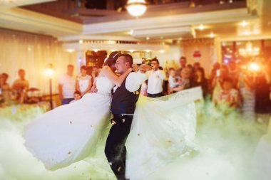 Mutlu gelin ve damat ve ilk dansları, zarif restoranda harika bir ışık ve atmosferi olan düğün.