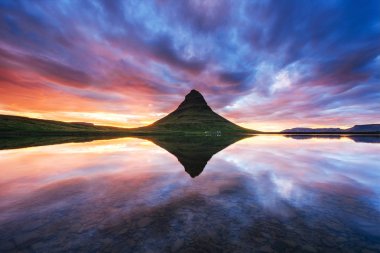 Manzaralar ve şelaleler üzerindeki resimli günbatımı. Kirkjufell Dağı, İzlanda 