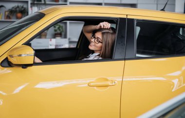 Arabanın ön koltuğunda kameraya bakarak çekici genç beyaz bir kadın