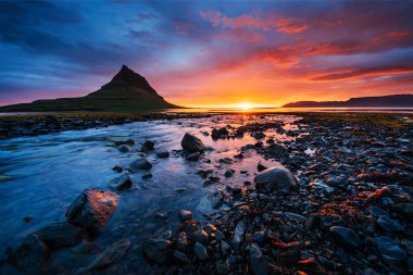 Manzaralar ve şelaleler üzerindeki resimli günbatımı. Kirkjufell Dağı, İzlanda 