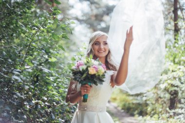 Mutlu bir gelin peçe ile poz portresi.