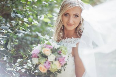 Mutlu bir gelin peçe ile poz portresi.